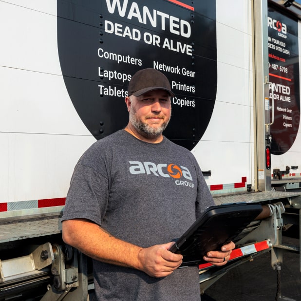 ARCOA employee holding a tablet behind an ARCOA truck