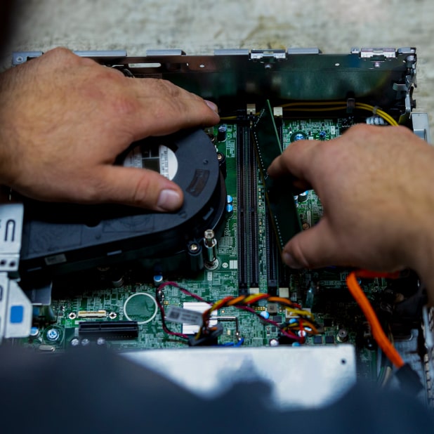 Close-up of a man’s hands disassembling a computer